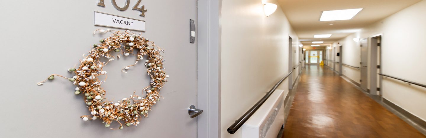 Decorative wreath on door in hospital corridor.